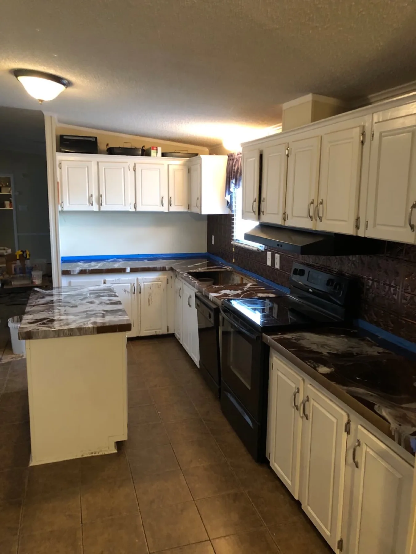 Brown and white marbled epoxy countertops with blue tape still up in a Wayne County, North Carolina kitchen