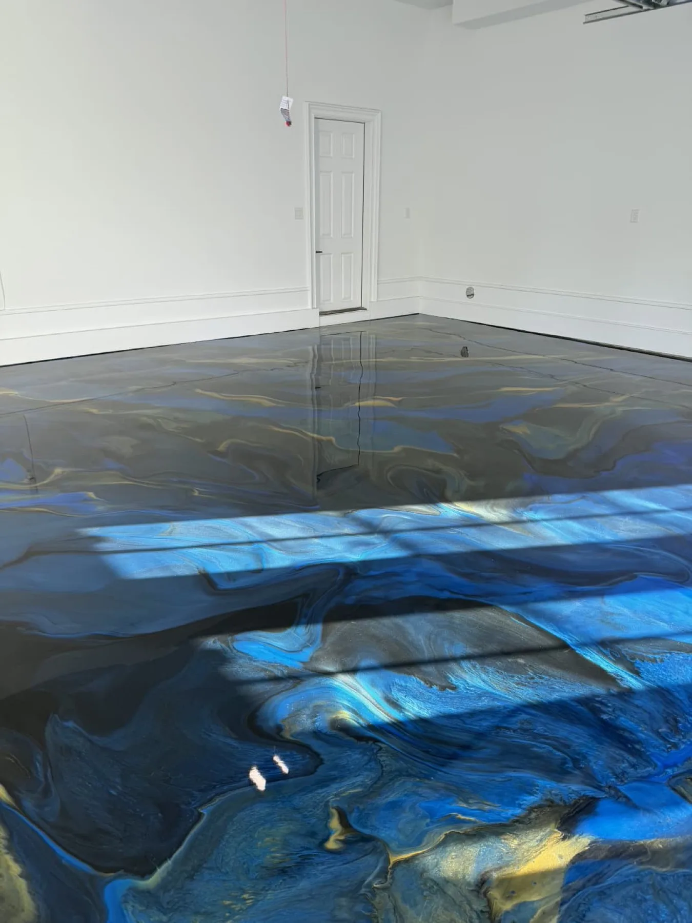 Blue metallic epoxy garage floor with a high gloss finish in Wayne County, North Carolina